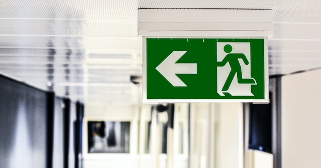green emergency exit sign in a hallways