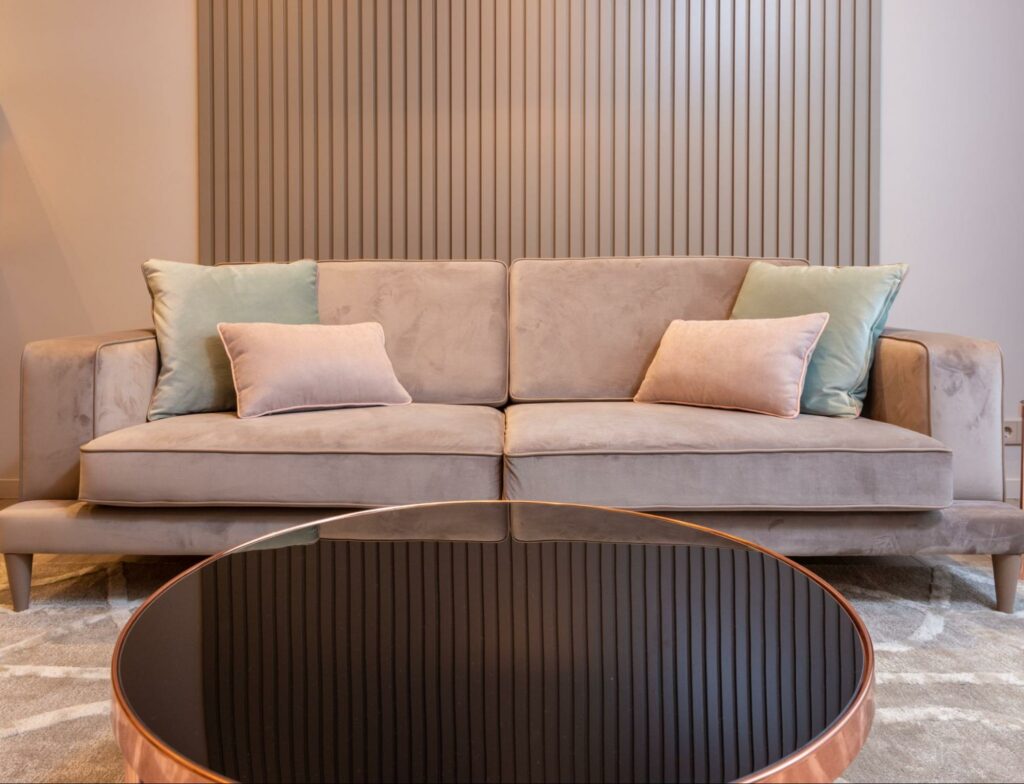 Shot of a living room with a gray couch and a round glass table
