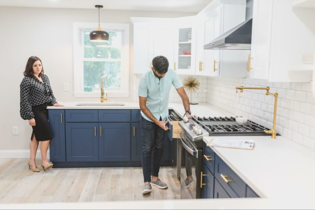 Two people inspecting a black and white kitchen
